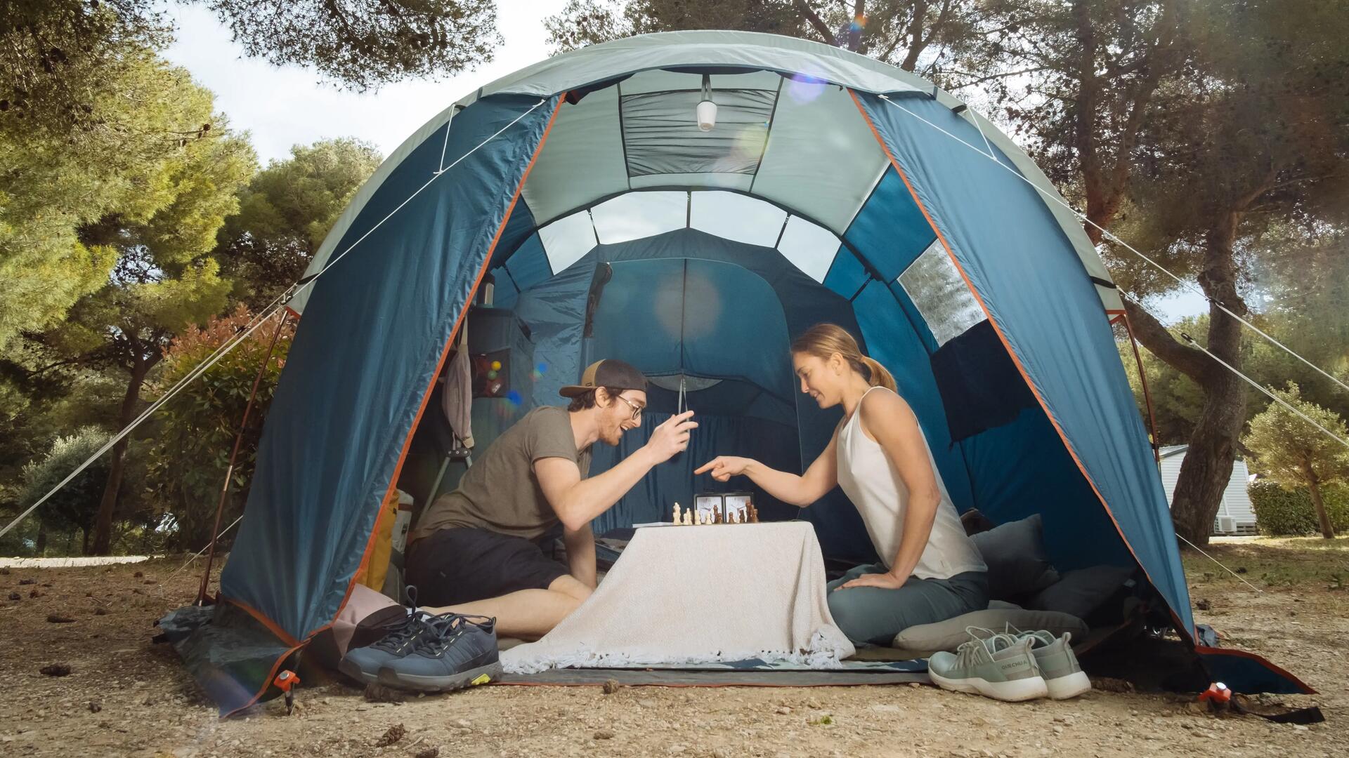 homem e mulher a jogar xadrez numa tenda em acampamento decathlon