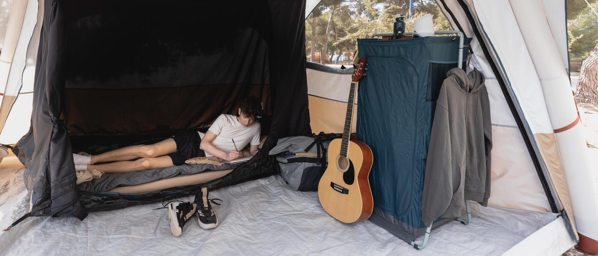 jovem rapaz dentro de uma tenda a escrever 