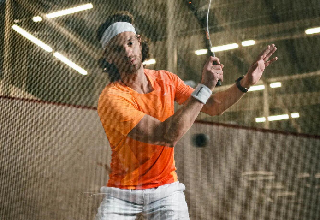 mężczyzna w kuszulca do gry w squasha trzymający rakietę do squasha