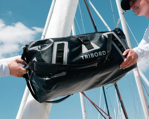 photo du sac étanche noir tribord 60 litres dans les mains de deux personnes
