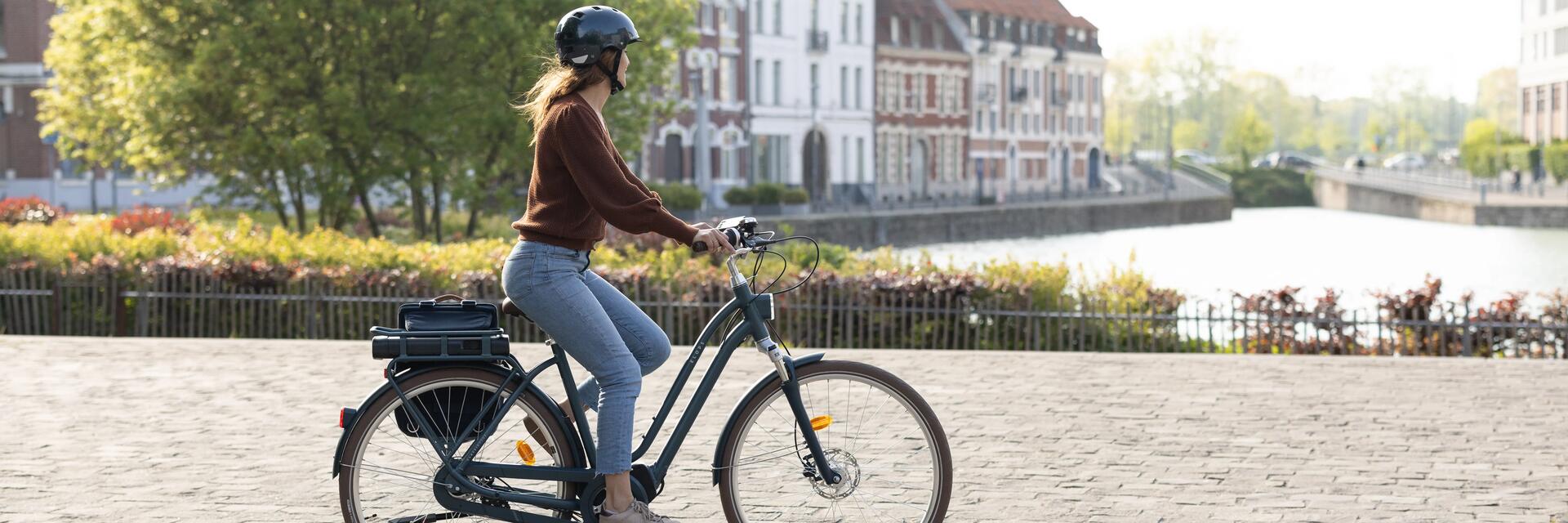 Kobieta jadąca na rowerze elektrycznym w kasku