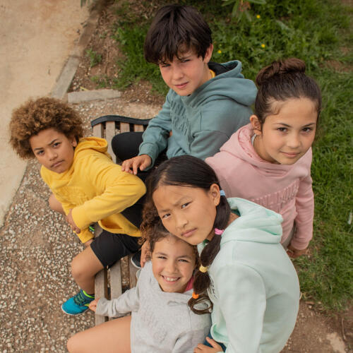 grupo de crianças sentadas com as diferentes cores de camisola de capuz