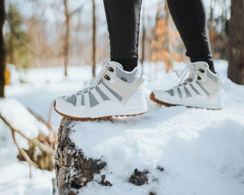 kobieta w legginsach stojąca na śniegu w butach zimowych