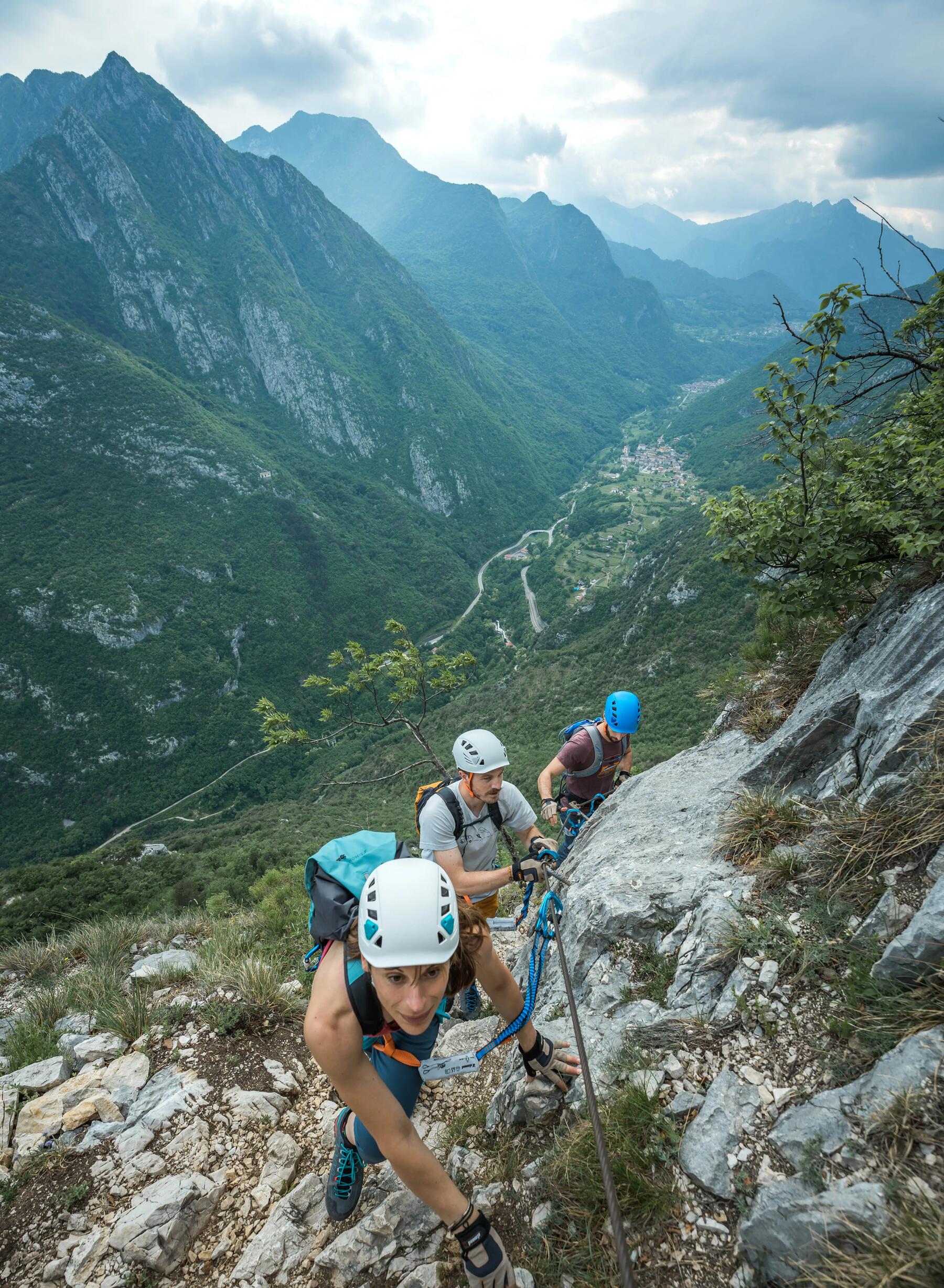 Grupa ludzi na szlaku vi ferrata ze sprzętem alpinistycznym