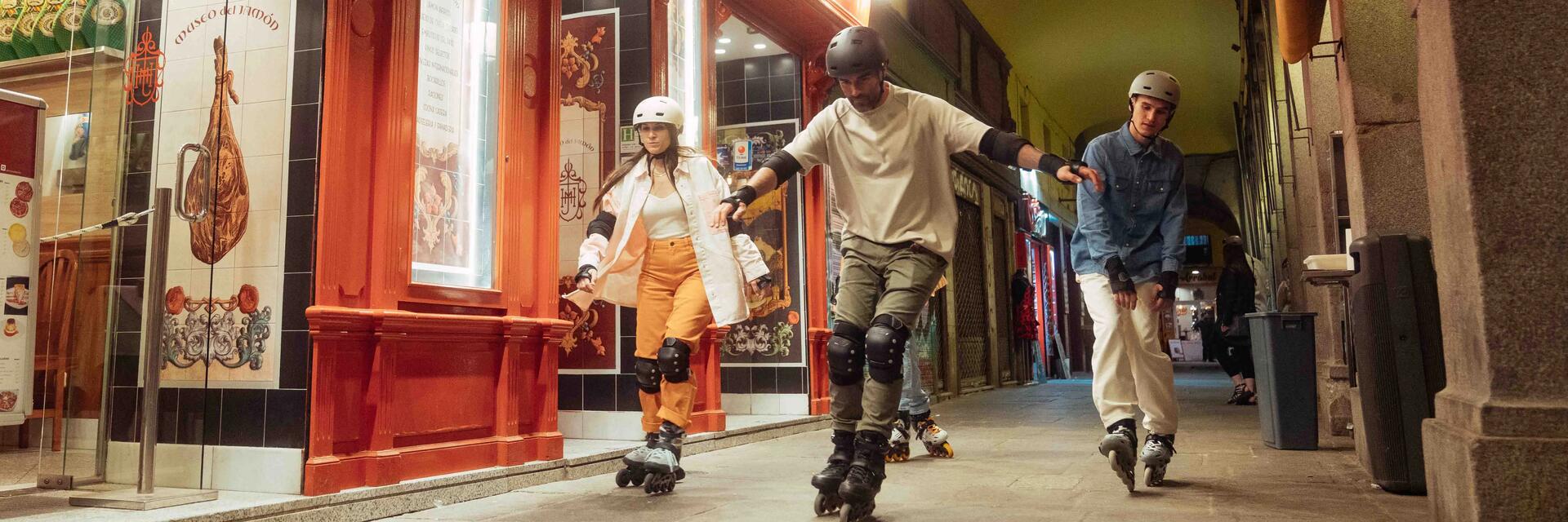 Two people sitting outside and wearing inline skates