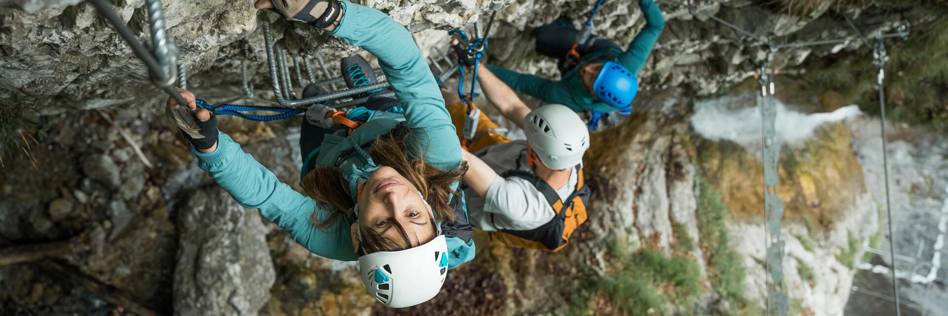 Drei Personen sind an einem Klettersteig