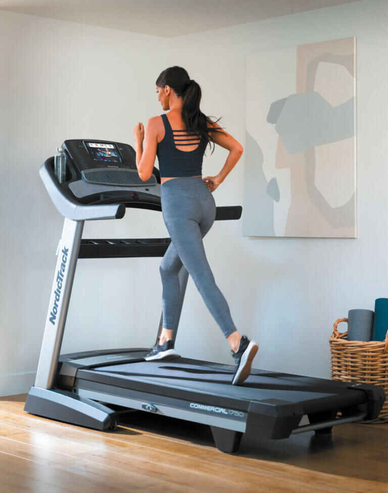 Girl is using a treadmill inside the house