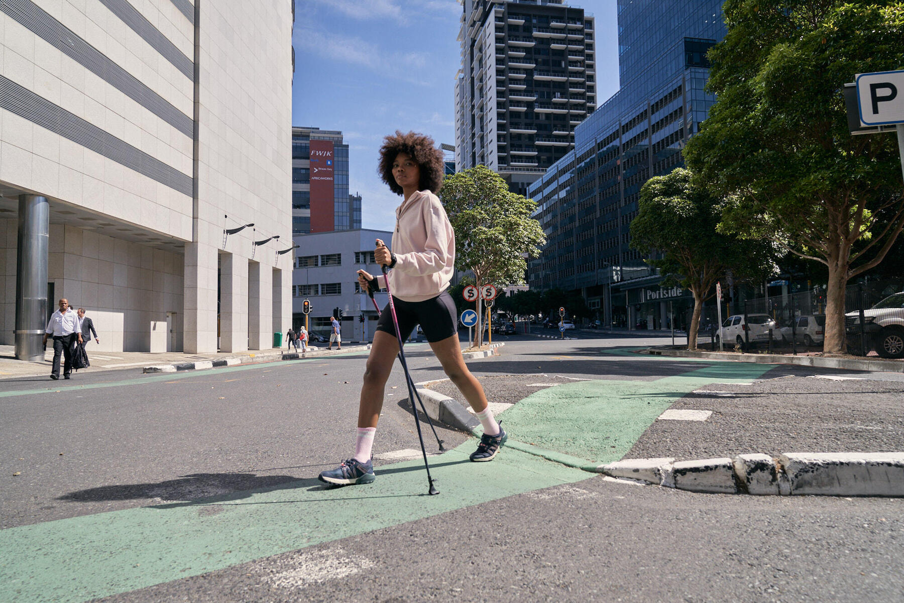 Kobieta w odzieży sporotwej ćwicząca nordic walking po mieście