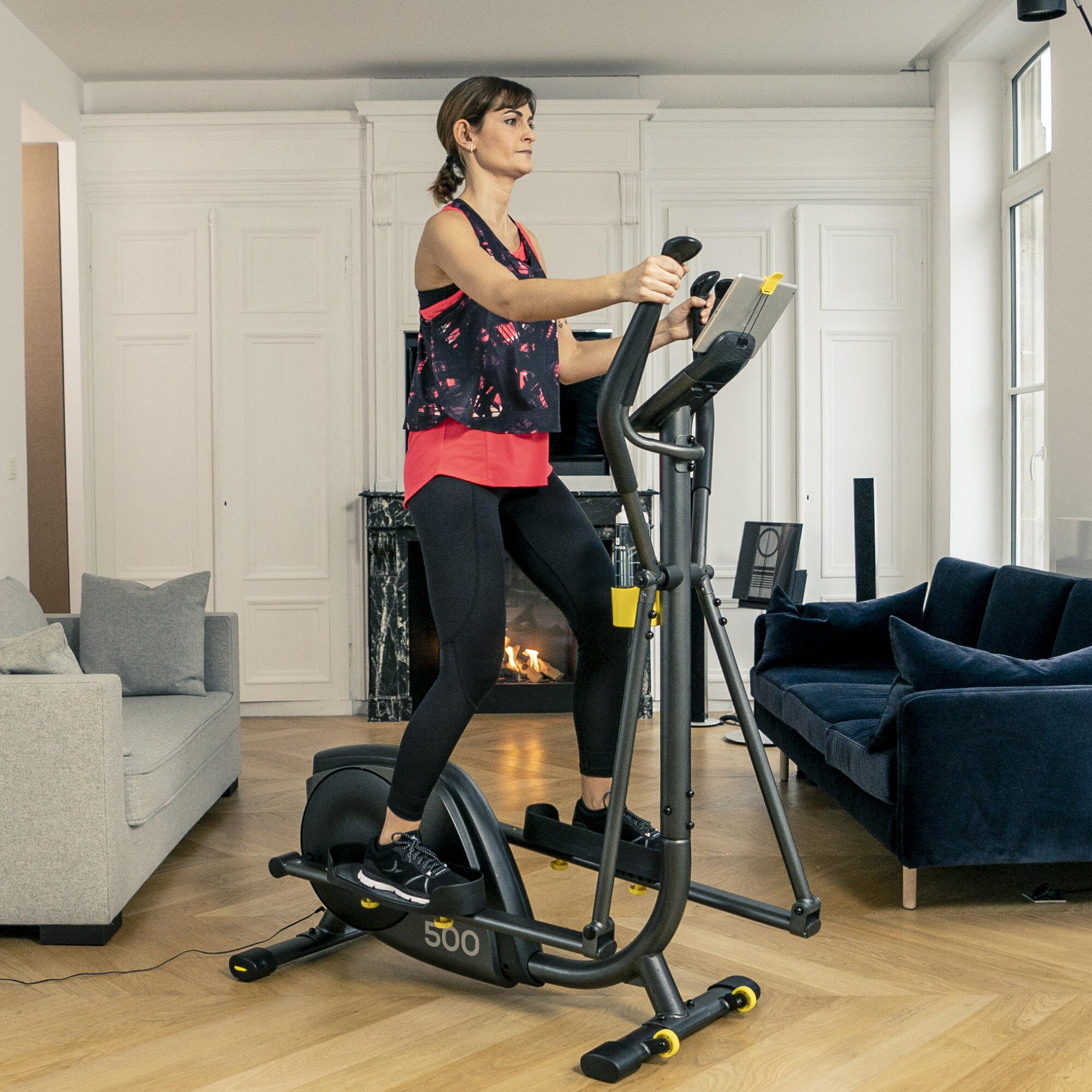 une femme utilisant un vélo elliptique d'entraînement 500 portant ses vêtements de sport