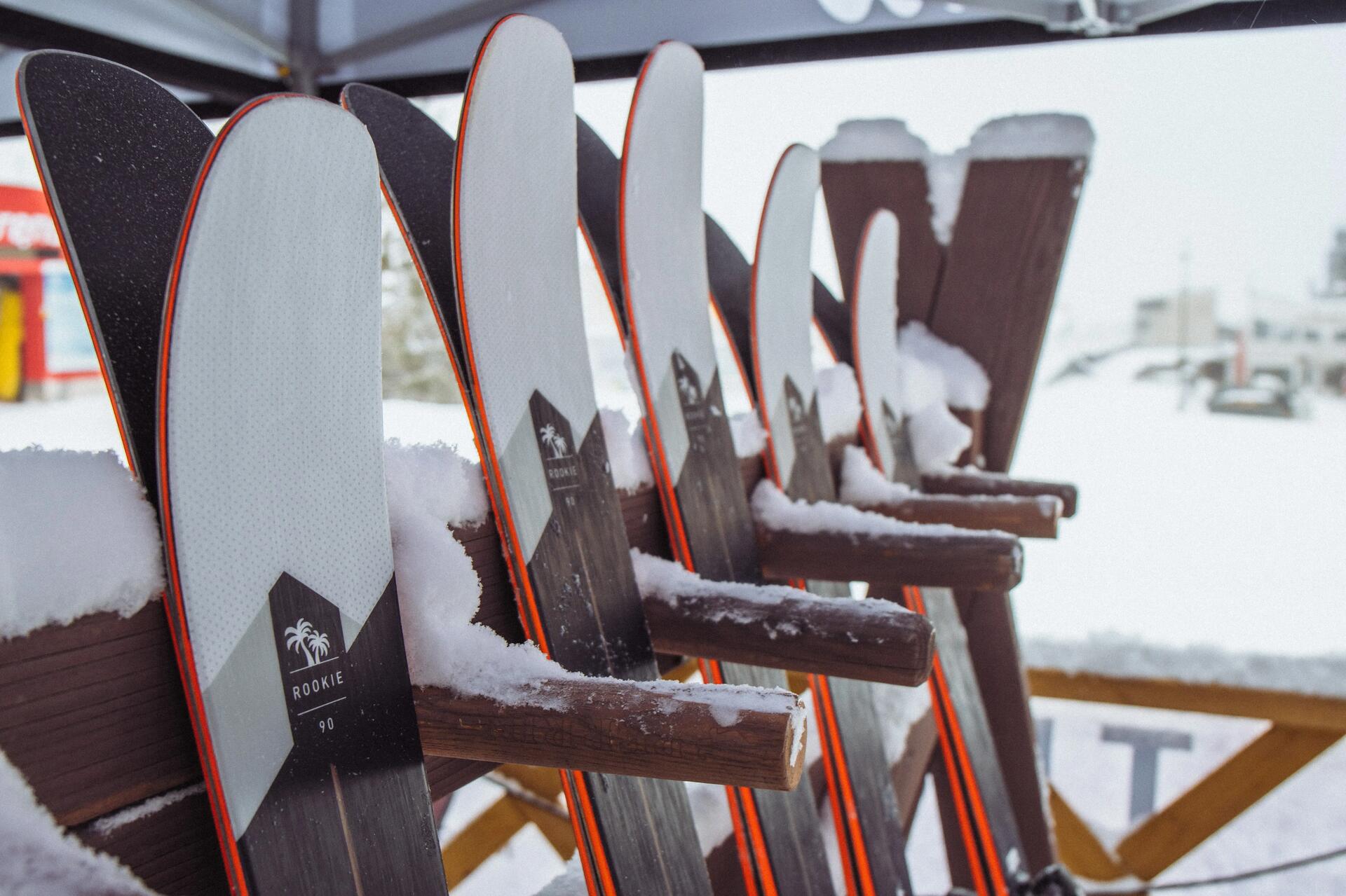 narty oparte o stojak w ośrodku narciarskim 