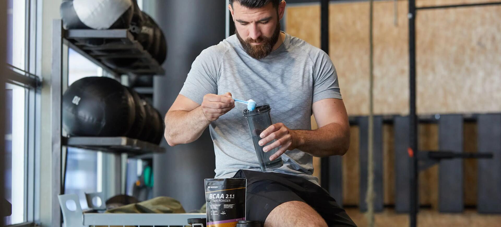 Man adding protein powder in his bottle