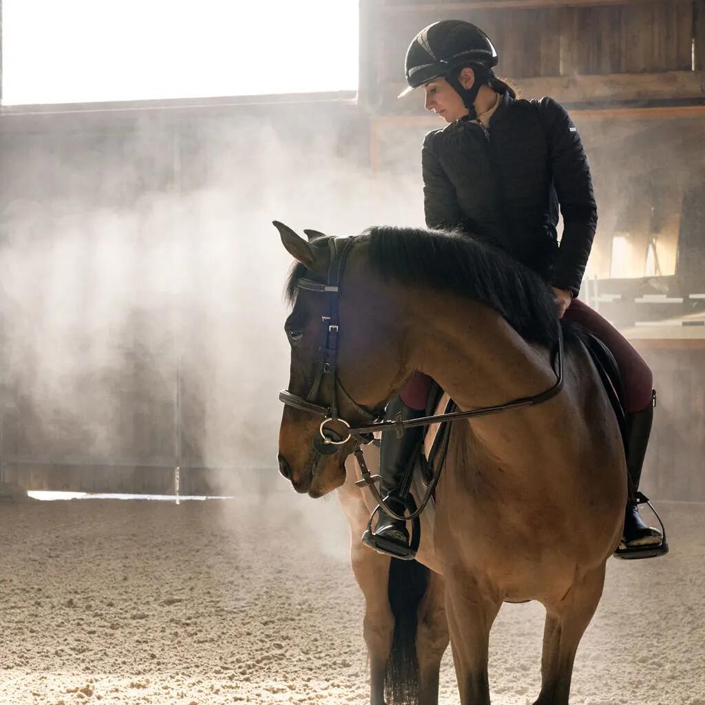 Kobieta w odzieży jeździeckiej nawiązująca więź z koniem po upadku z konia
