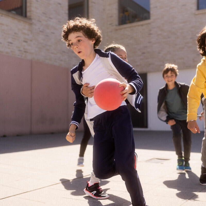 Crianças na aula de educação física a jogar um jogo com bola