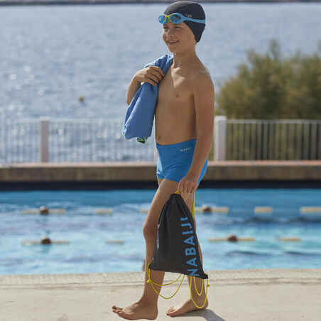 Niño con gorro de baño y gafas de natación en la piscina