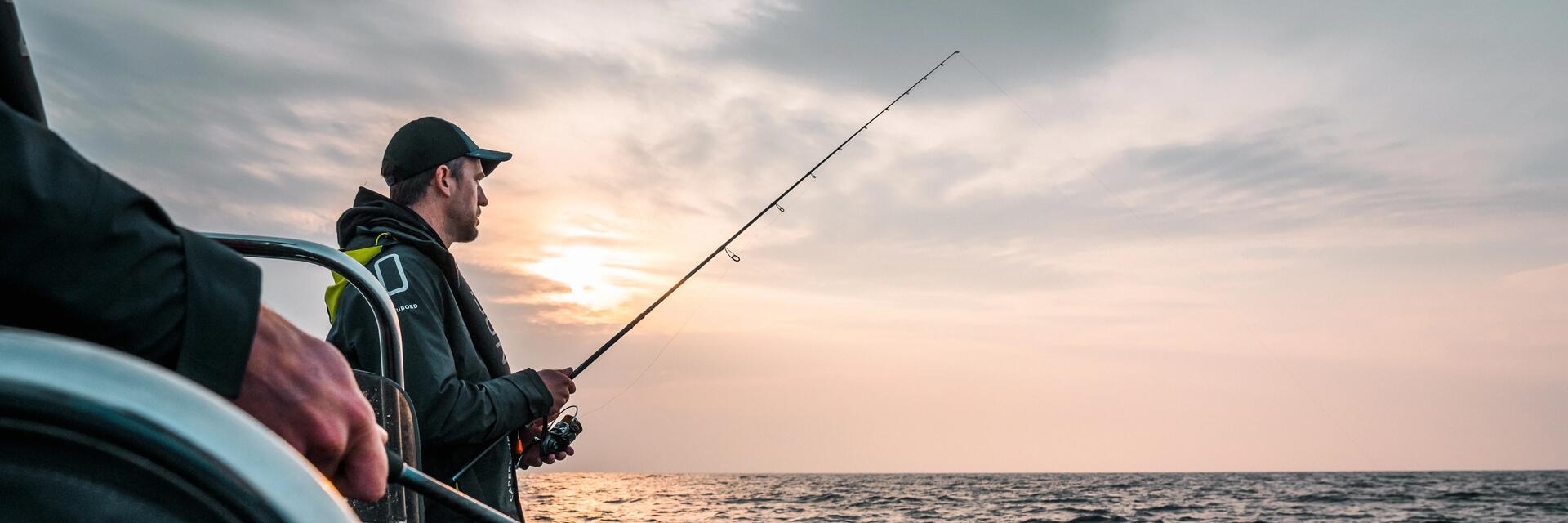 Angler steht auf einem Boot auf dem Meer mit der Angel in der Hand