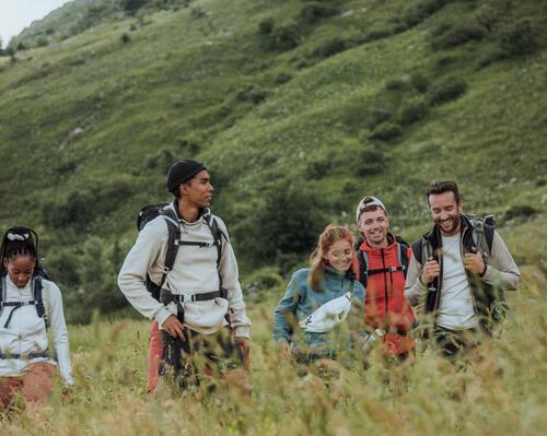 Grupa ludzi w trakcie trekkingu ubrana w polary z plecakami turystycznymi