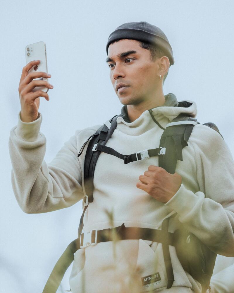 Ein Mann hält sein Smartphone in der Hand und schaut konzentriert darauf.