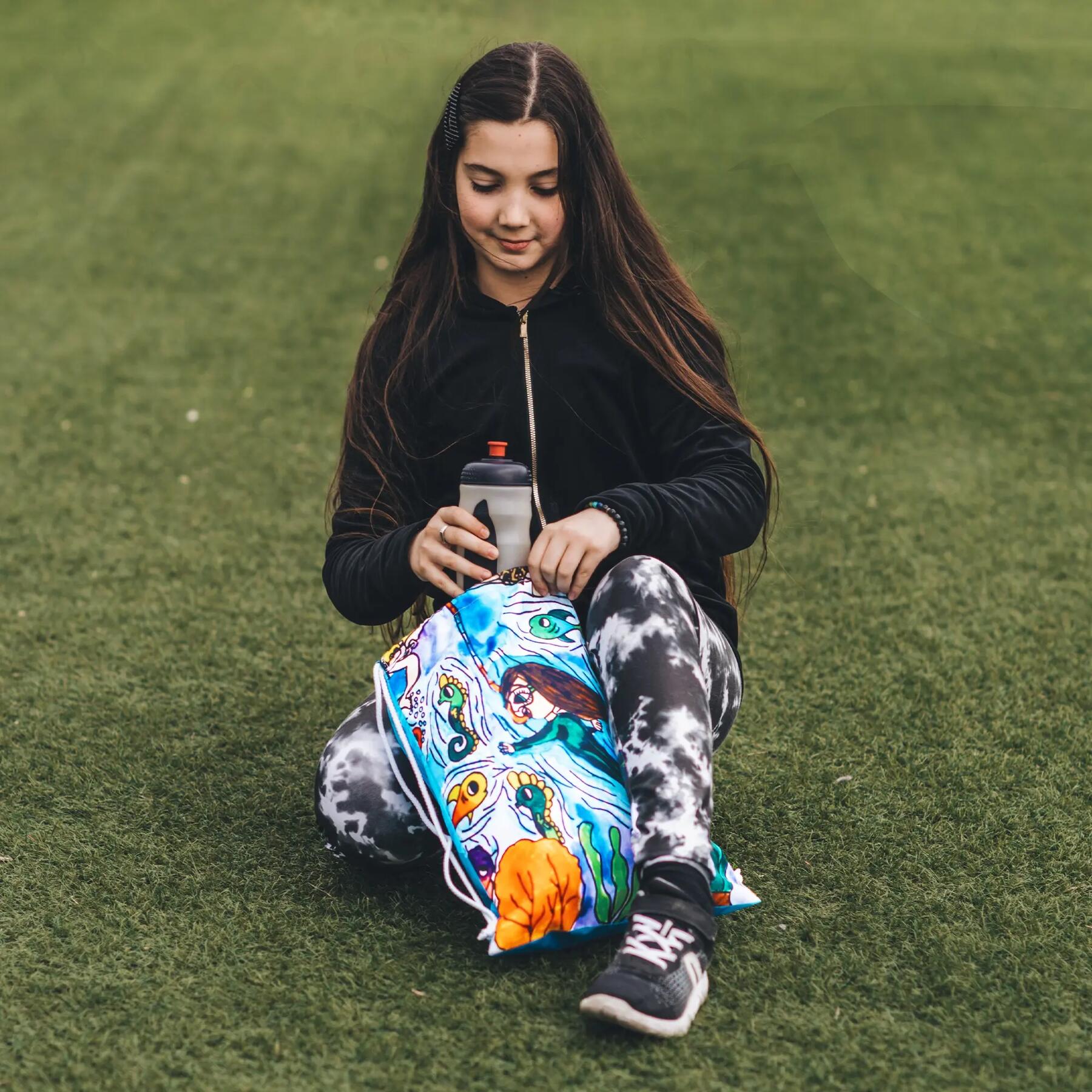 Een meisje haalt een drinkbus uit haar sporttas