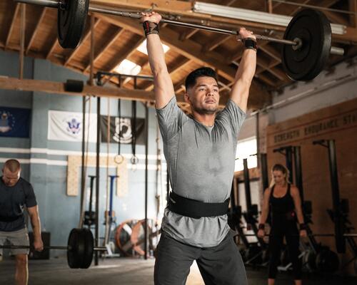 mężczyźni i kobieta w odzieży fitness trenujący crossfit