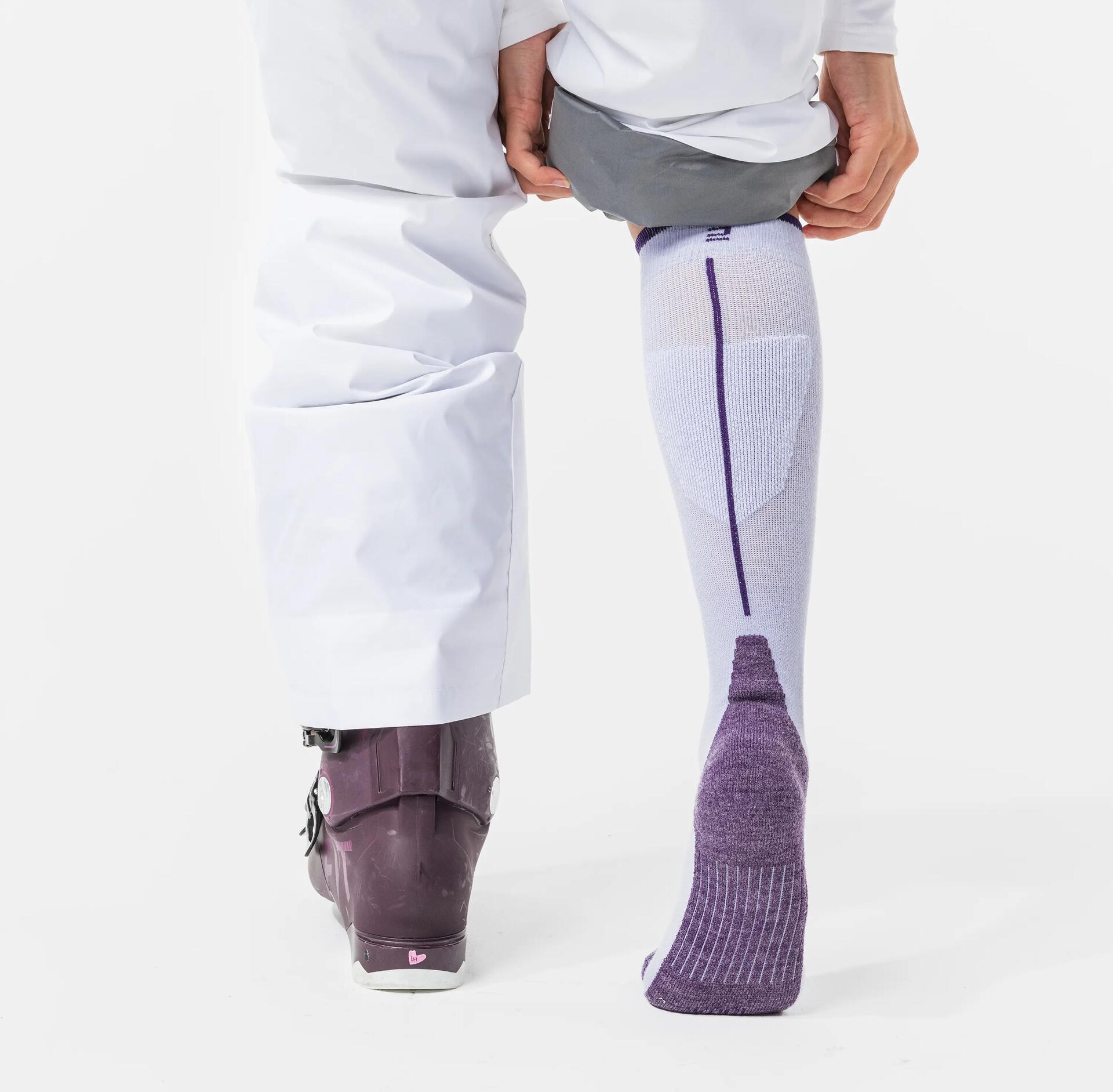 a close up of someone adjusting their ski socks