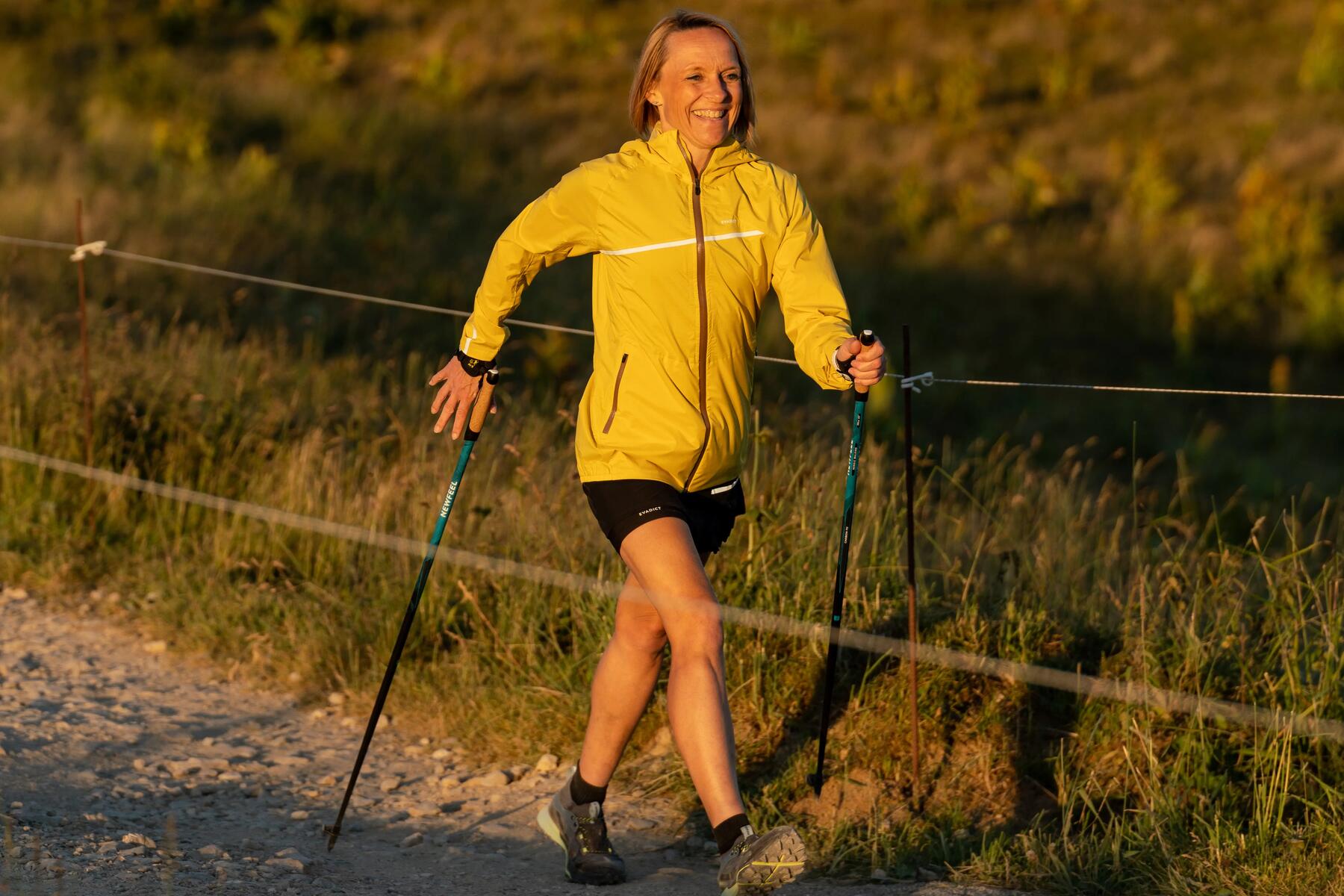 Zadowolona kobieta uprawiająca nordic walking jako ćwiczenie na rwę kulszową 