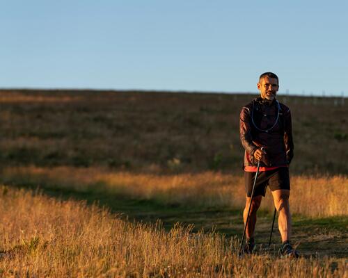 Mężczyzna idący z kijami do nordic walkingu