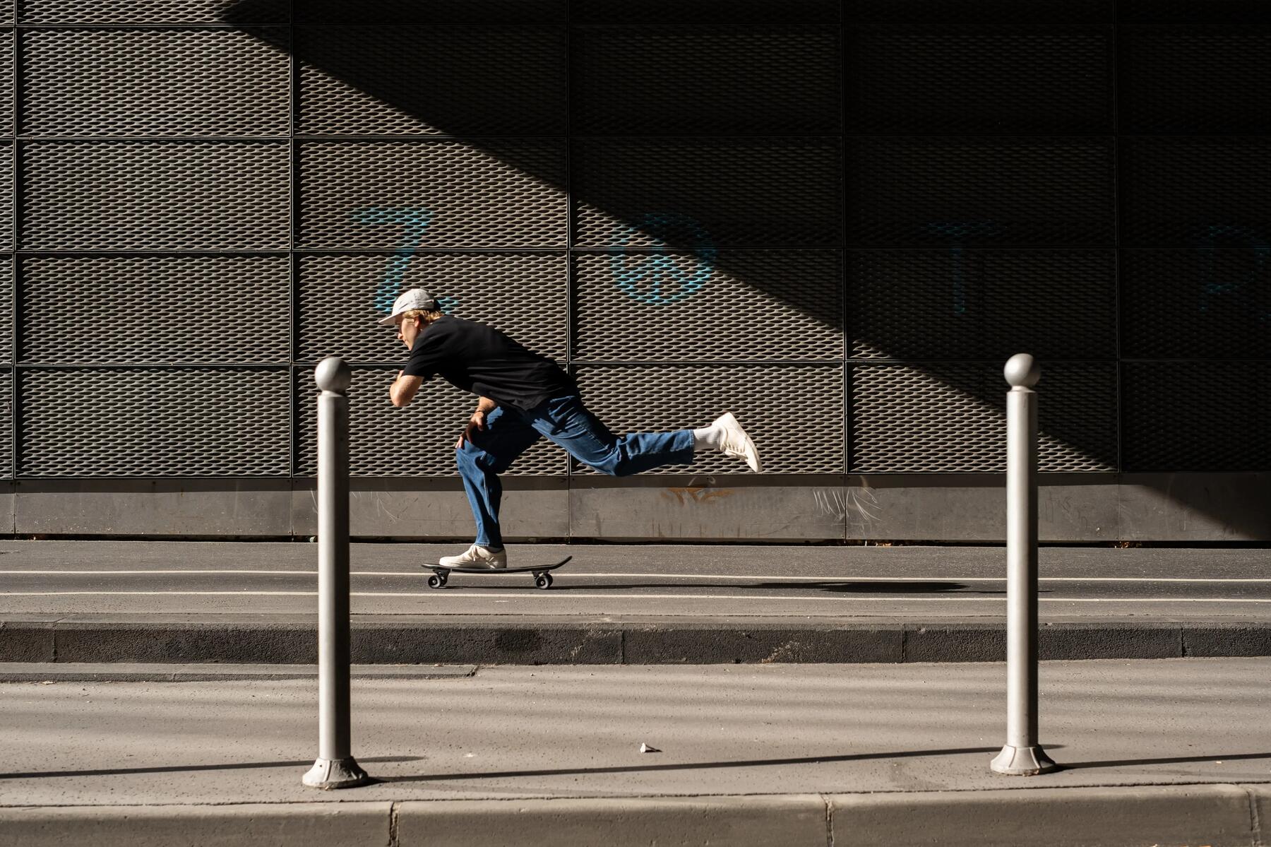 Chłopak jadący na longboardzie po chodniku