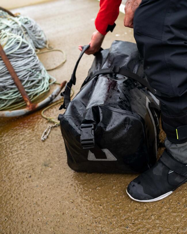 duffle bag 60L noir posé sur un quai