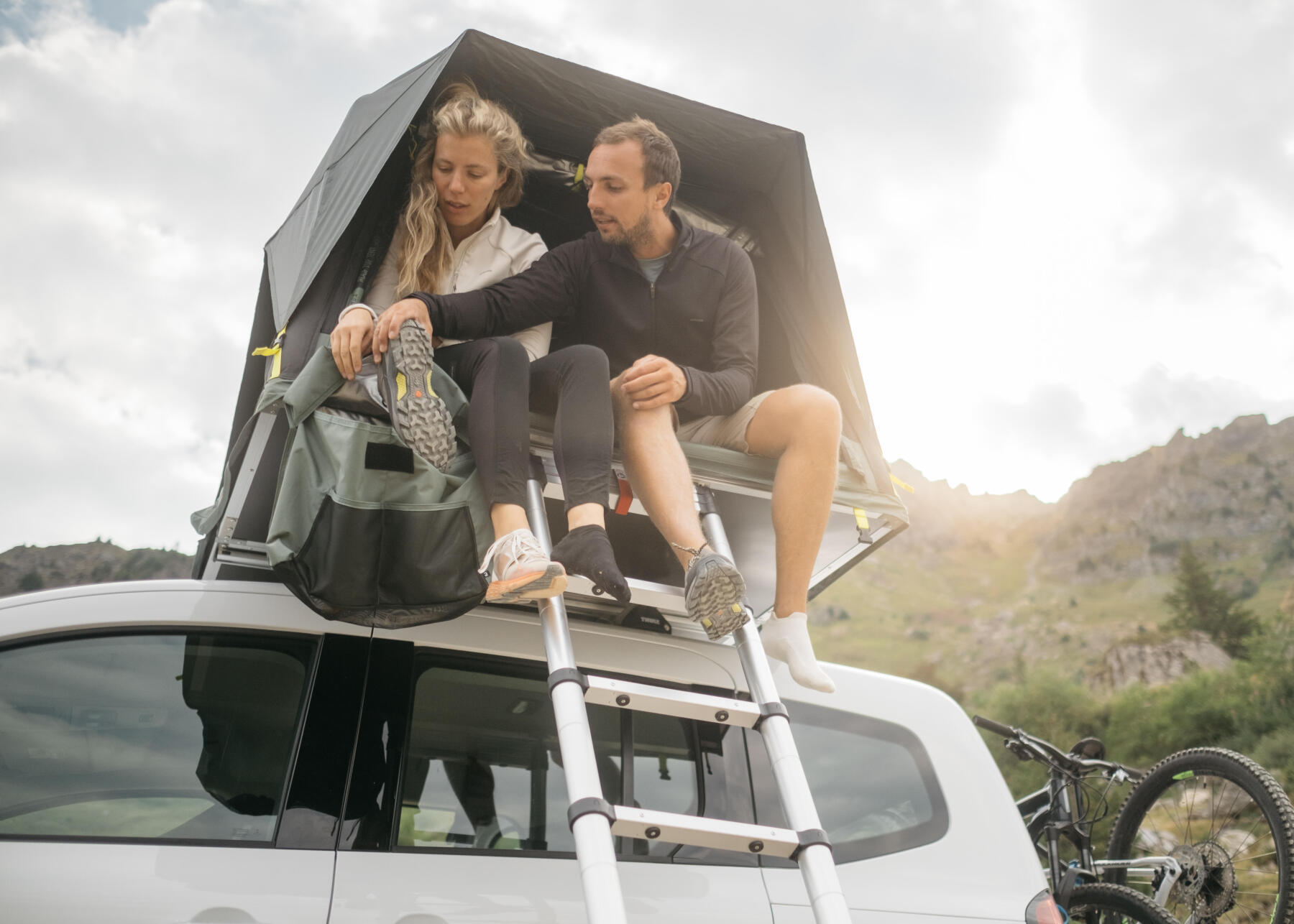 casal dentro da tenda de tejadilho decathlon