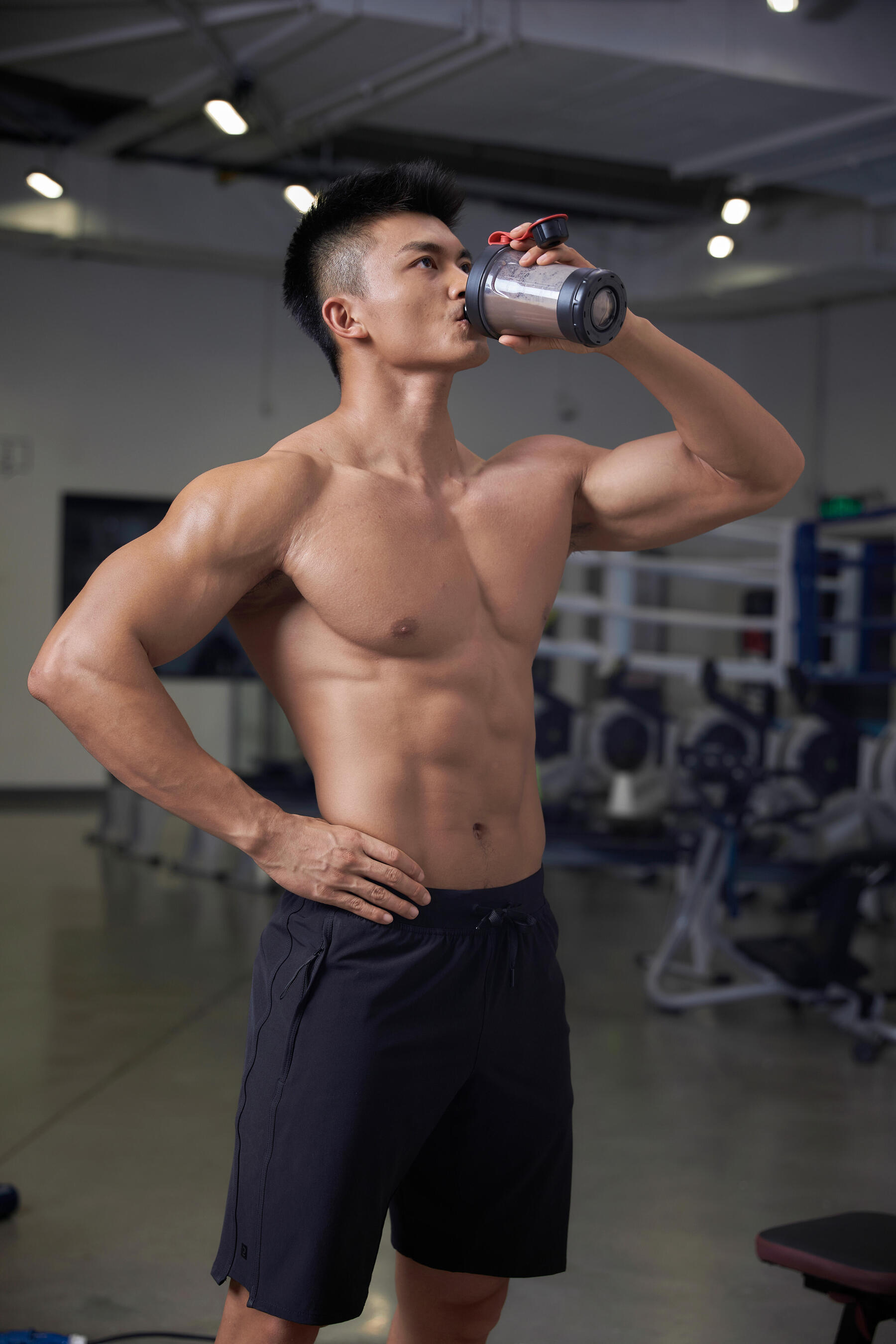 Mann trinkt einen Proteinshake nach dem Trainingsplan zum abnehmen im Fitnessstudio
