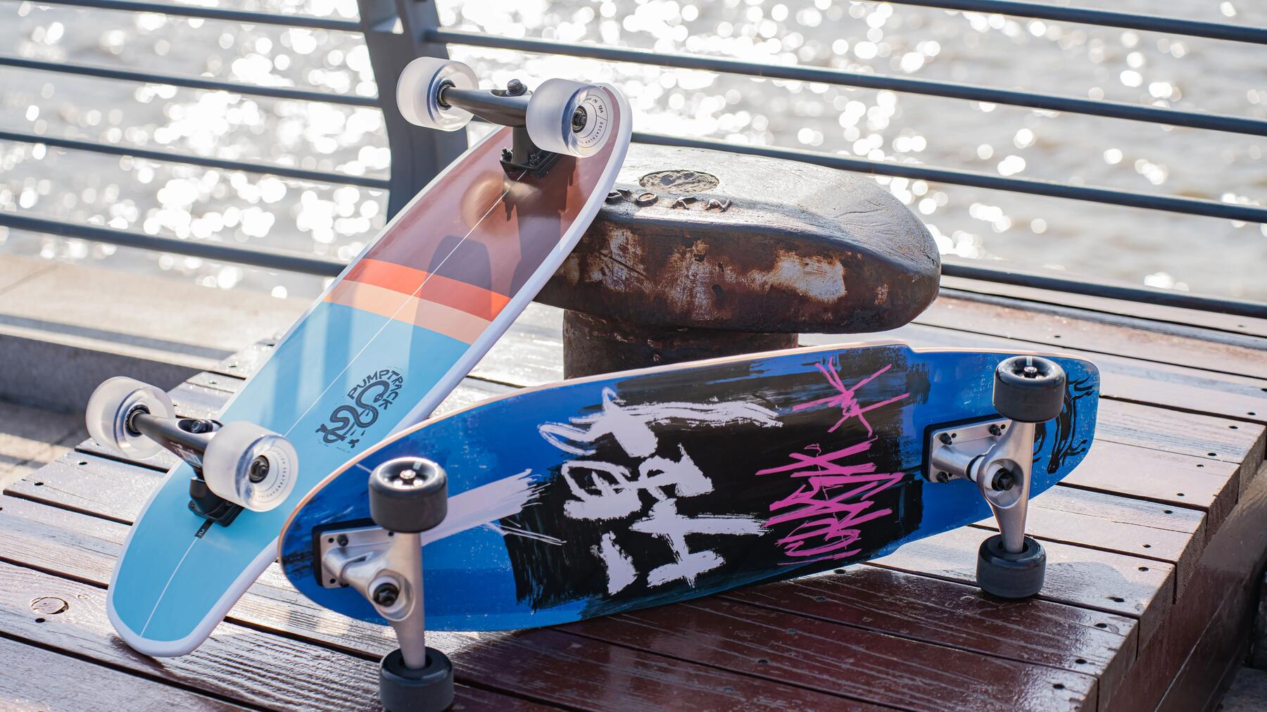 Deskorolki typu longboard leżące na pomoście