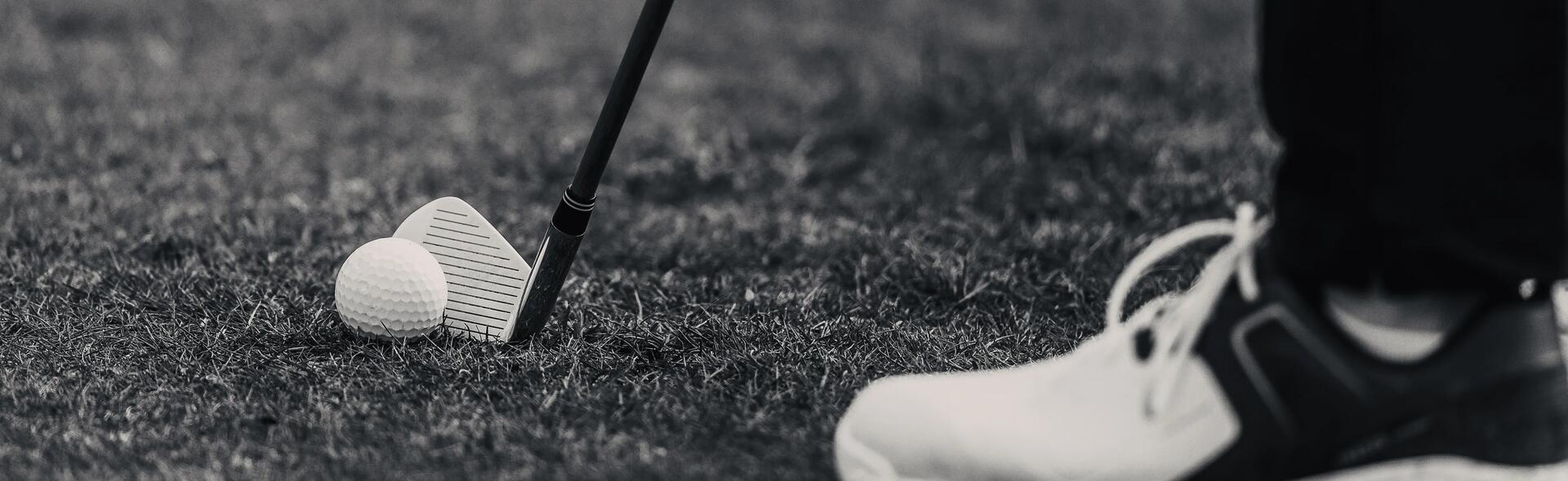 mężczyzna w butach golfowych trzymający kij przy piłeczce golfowej