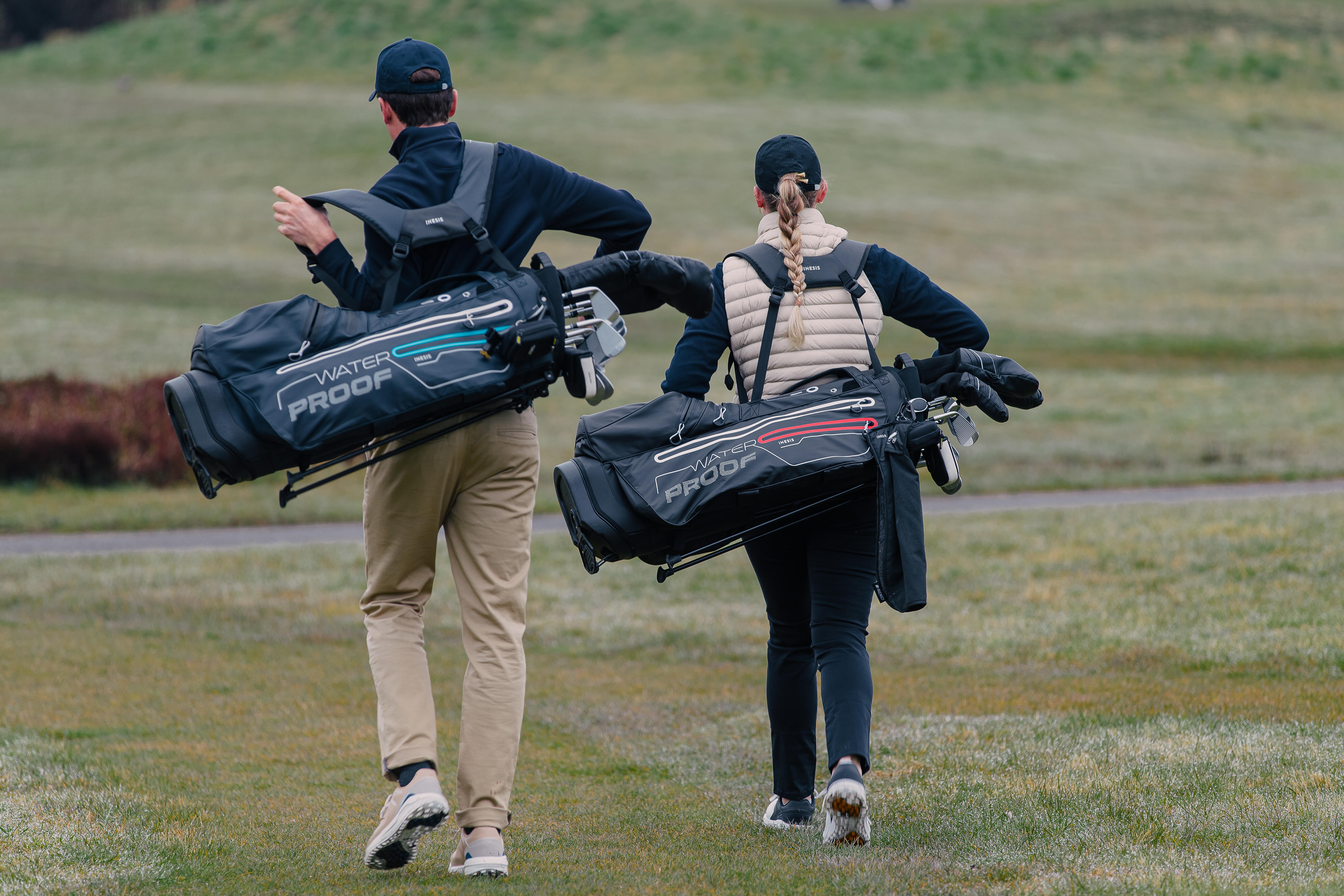 Hombre y mujer transportando bolsas para equipo de golf decathlon