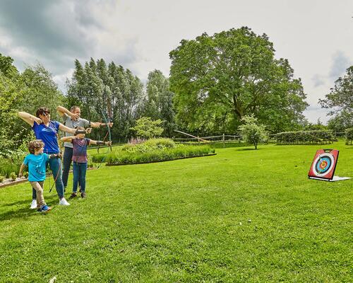 A family playing soft archery in the garden
