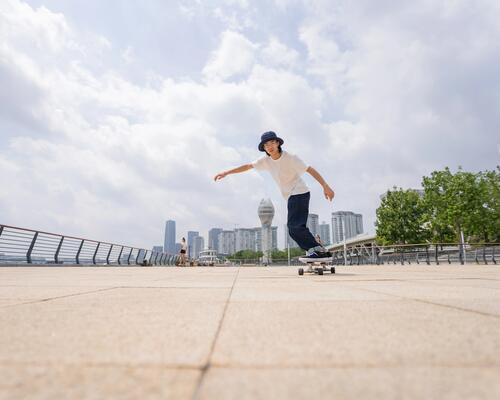 Deskorolkowiec jadący w mieście na deskorolce typu longboard