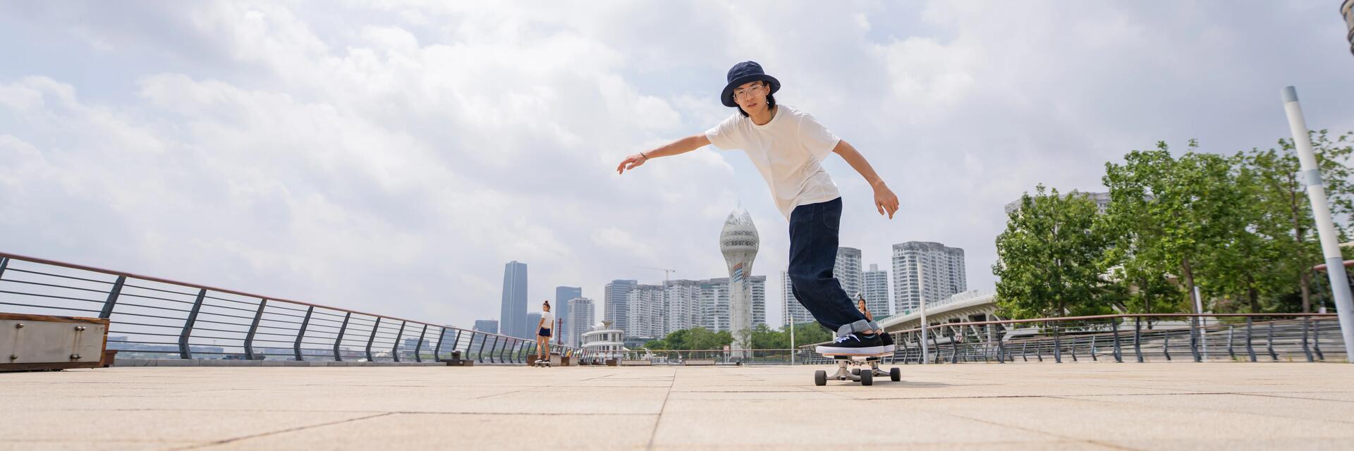 Deskorolkowiec jadący w mieście na deskorolce typu longboard