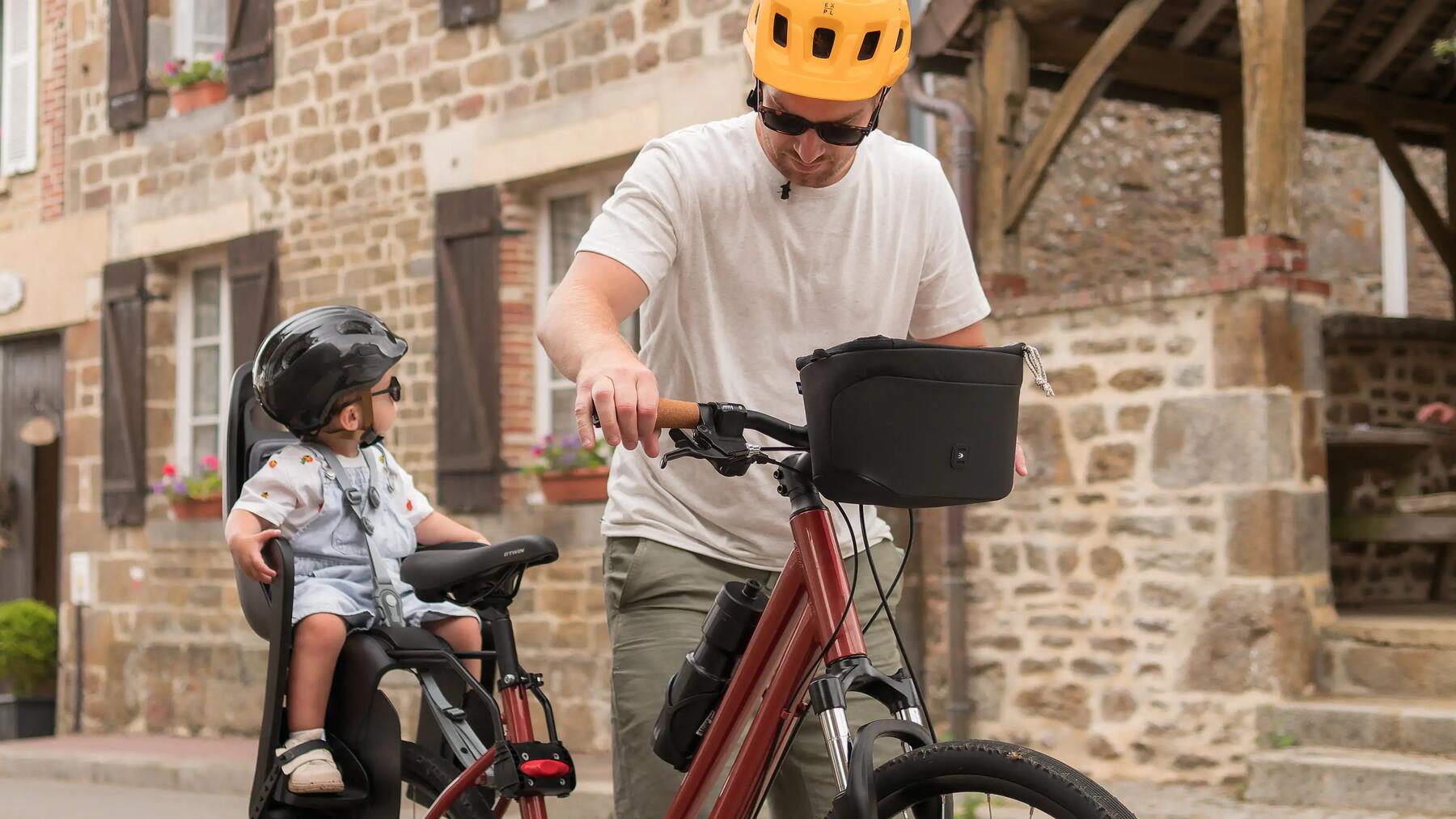 Homem com bebé na cadeirinha da bicicleta