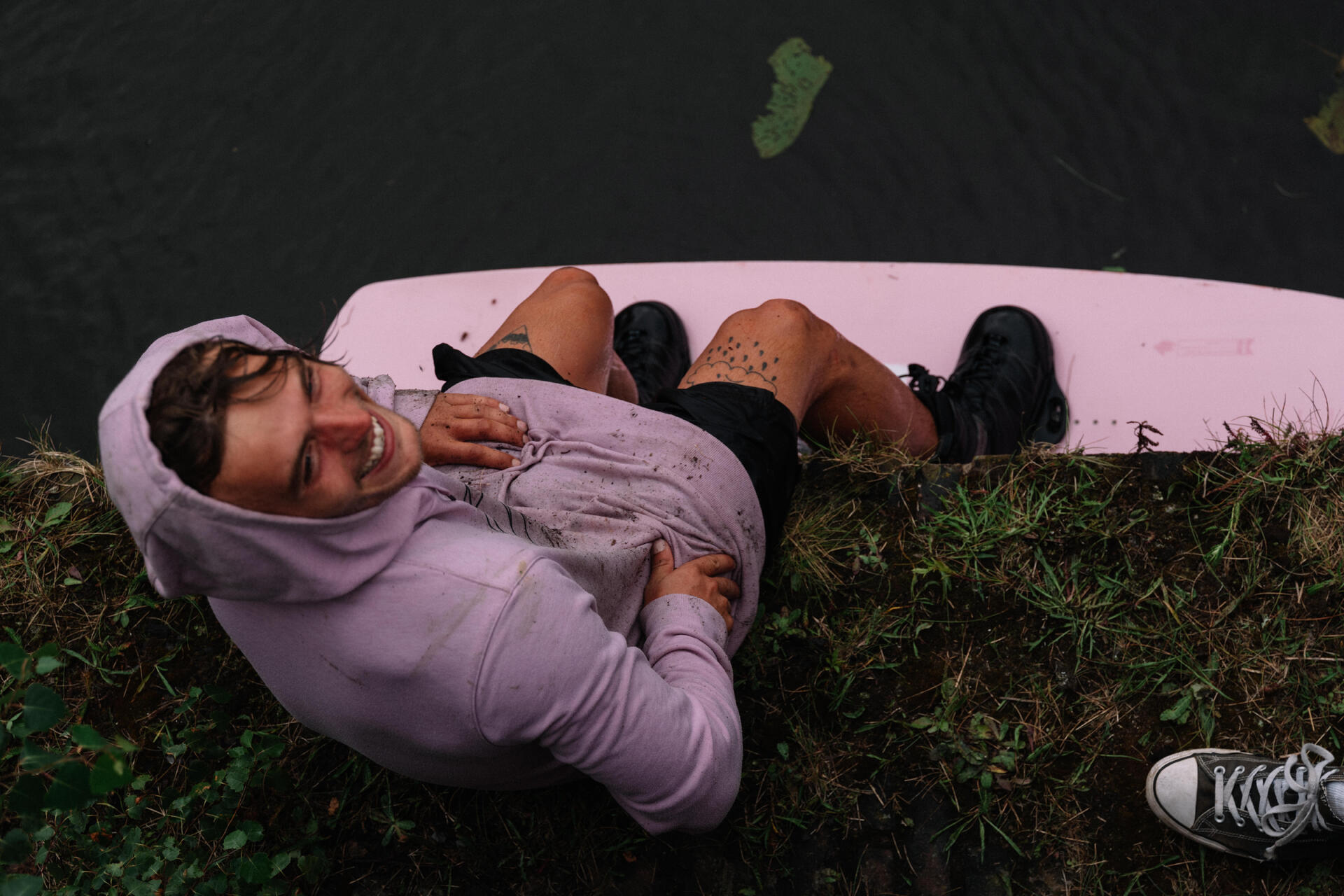Mężczyzna siedzący na pomoście w desce wakeboardingowej
