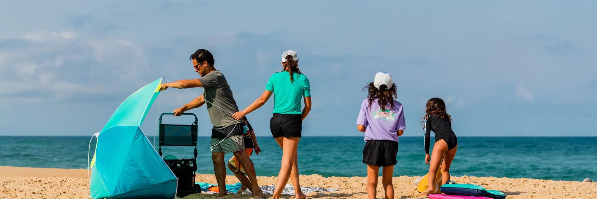 Mężczyzna rozkładający namiot plażowy