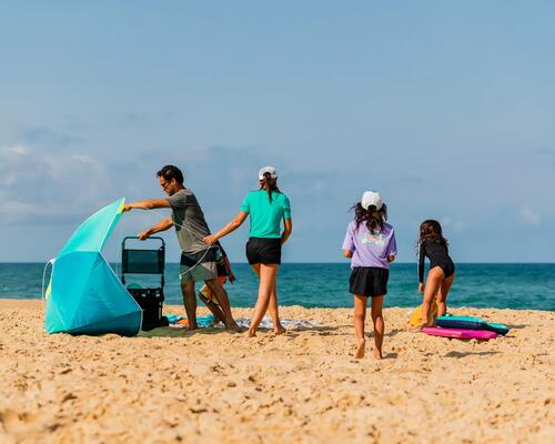 Mężczyzna rozkładający parasol na plaży