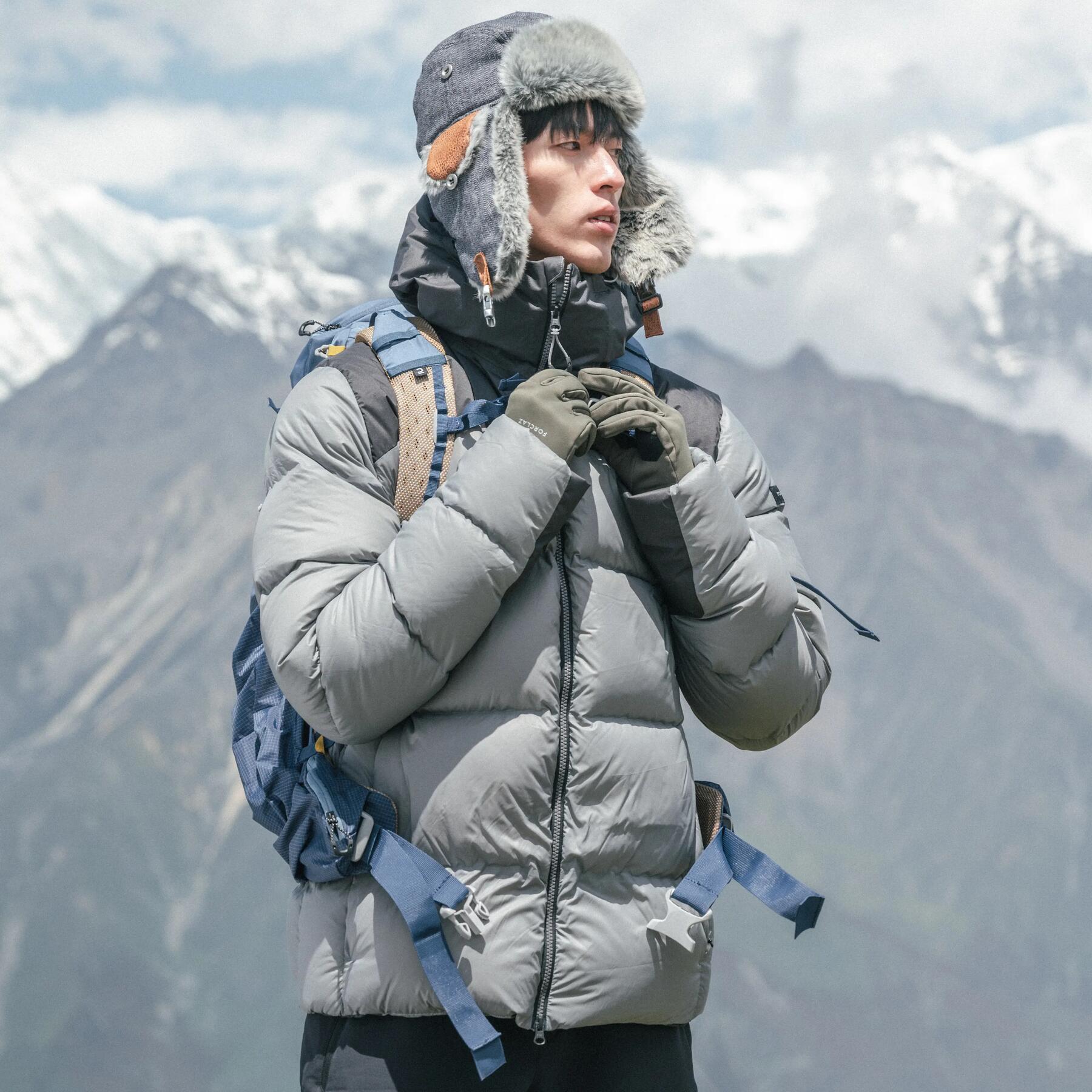 mężczyzna stojący w górach ubrany w kurtkę na trekking w Himalaje