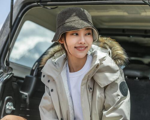 Kobieta ubrana w bucket hat siedząca w samochodzie przed trekkingiem