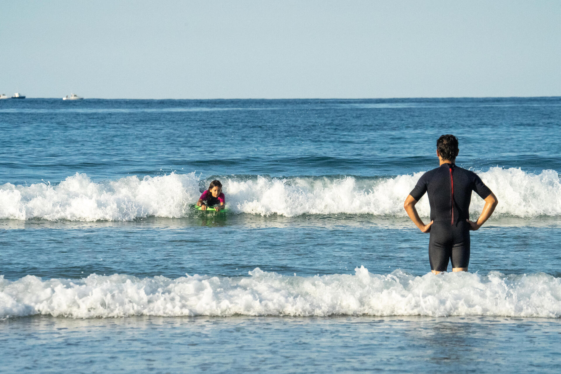 Dziecko trenujące bodyboarding pod kontrolą ojca 
