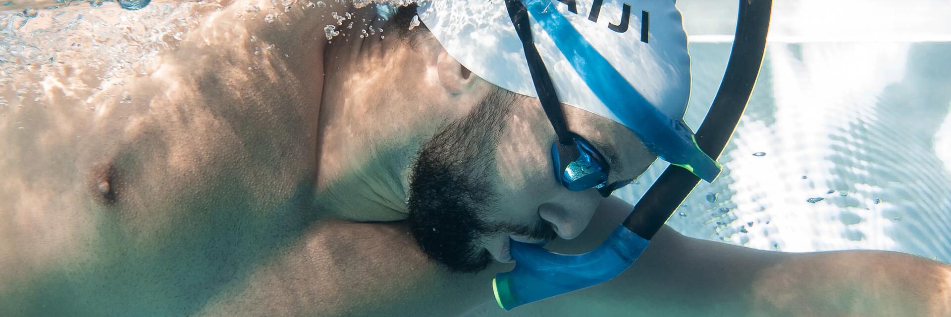 Mężczyzna z rurką czołową pływający w basenie