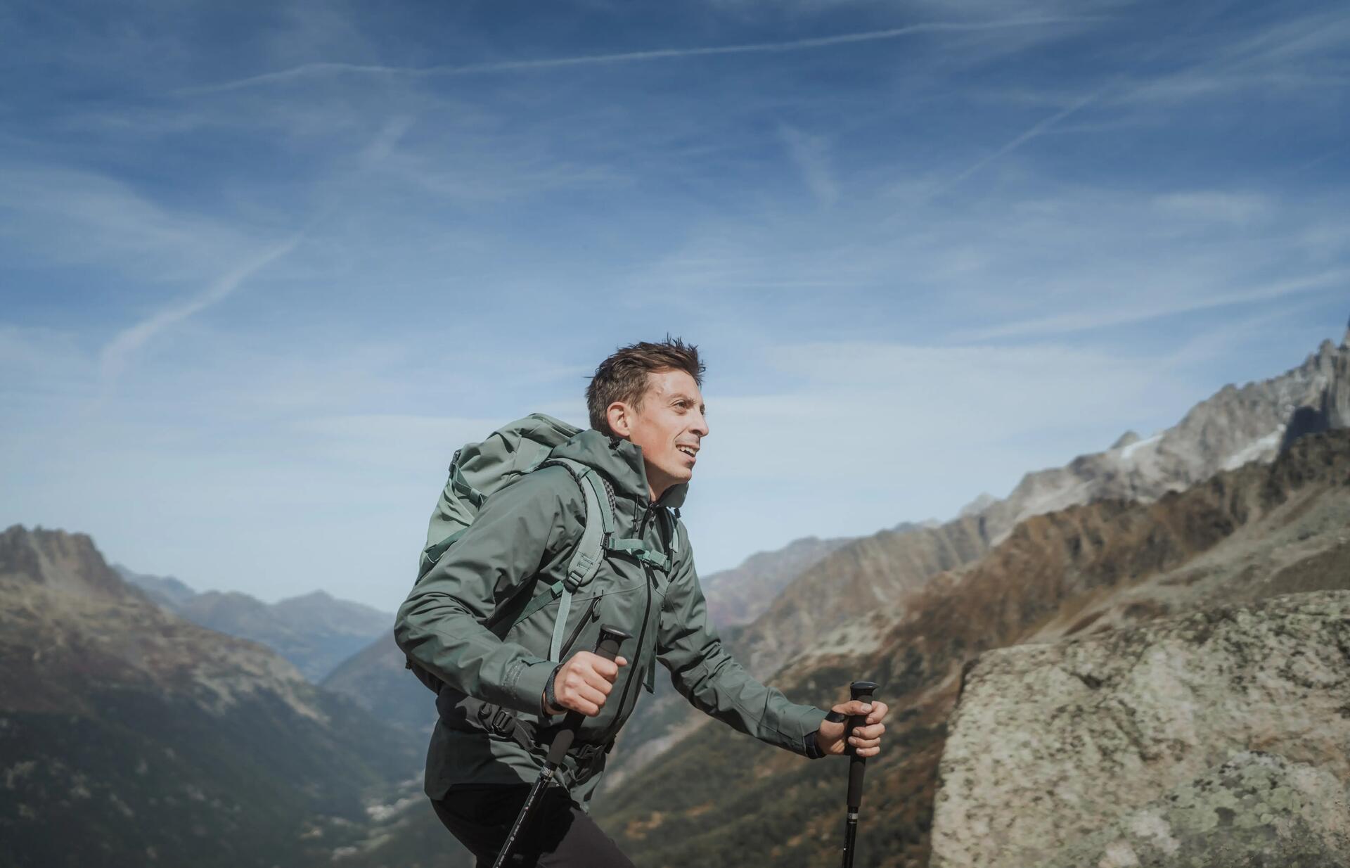mężczyzna w odzieży trekkingowej z plecakiem na plecach wędrujący po górach