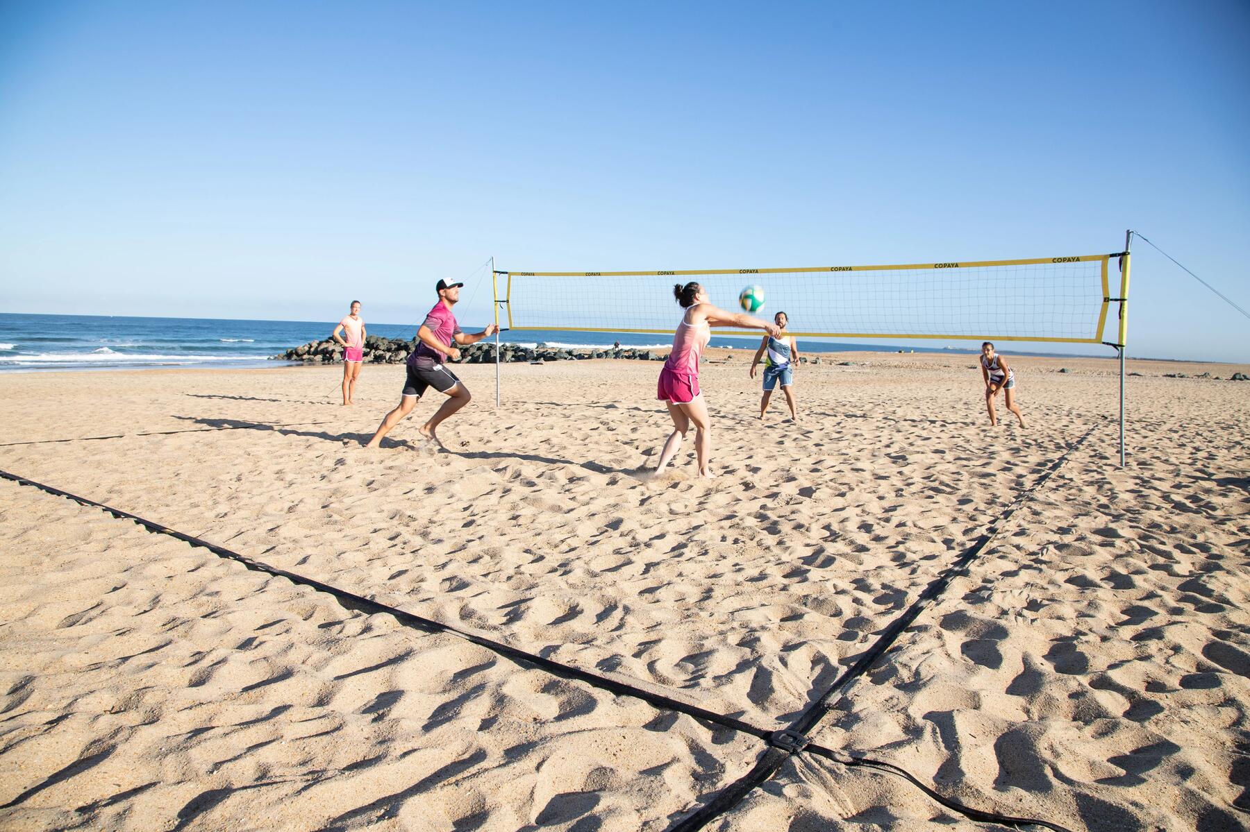 Znajomi grający w siatkówkę plażową posmarowani kremem z filtrem