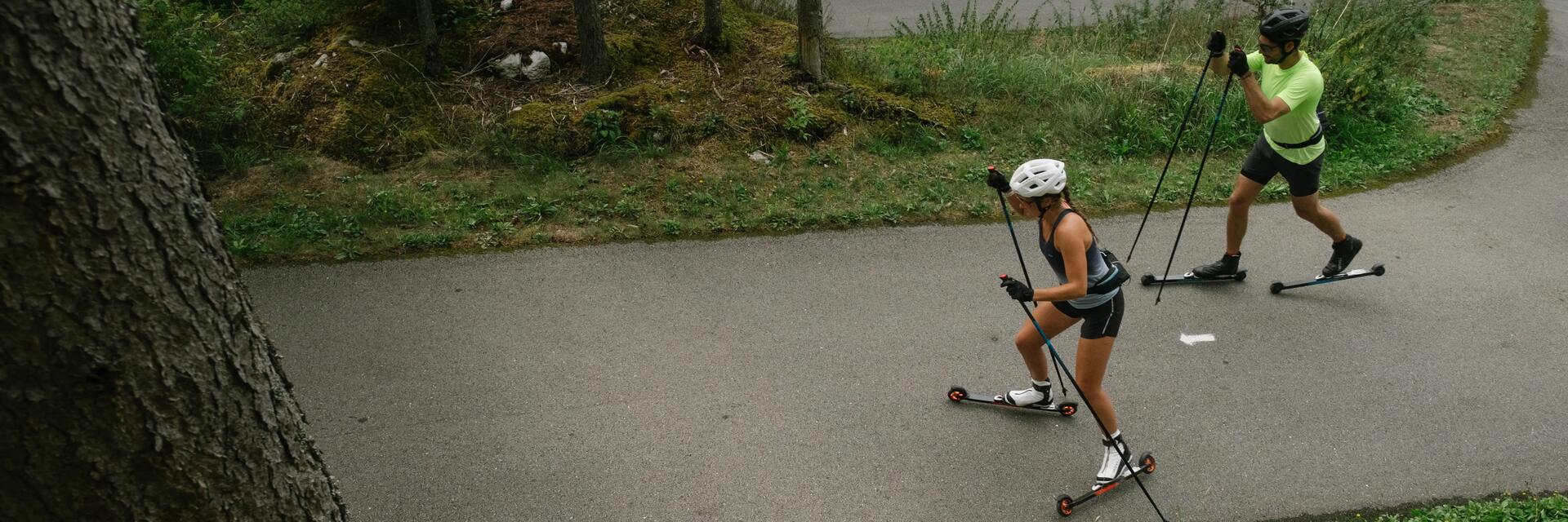 Para ucząca się hamować na nartorolkach