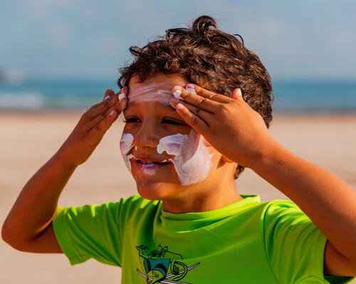 Une femme qui applique de la crème solaire sur son bras