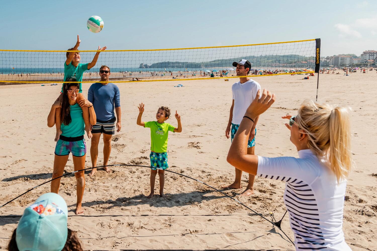 Familia jugando volley en la playa