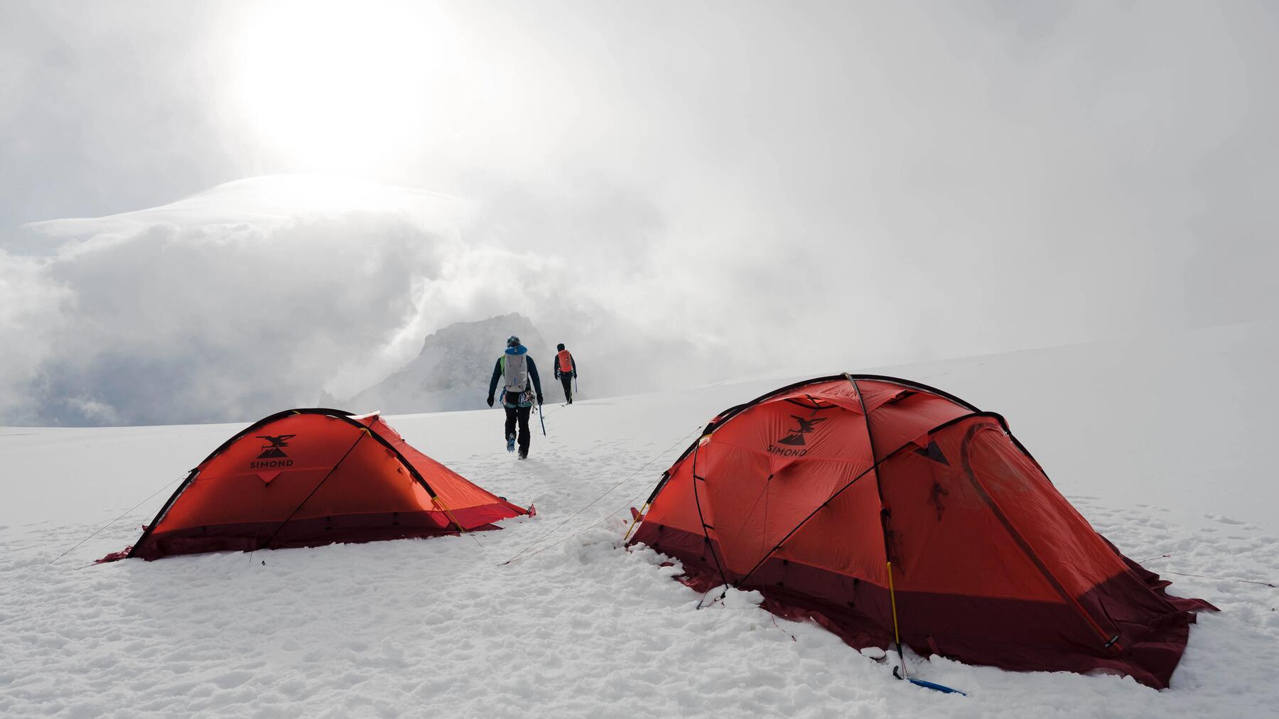 Zwei Personen campten mit Zelt im Winter auf dem Berg